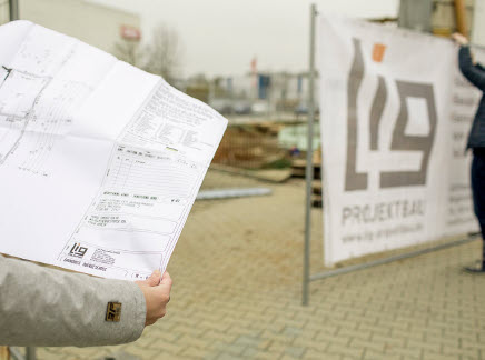 Leistungen bei der LIG. Bild zeigt Person mit einem Grundrissplan in der Hand.